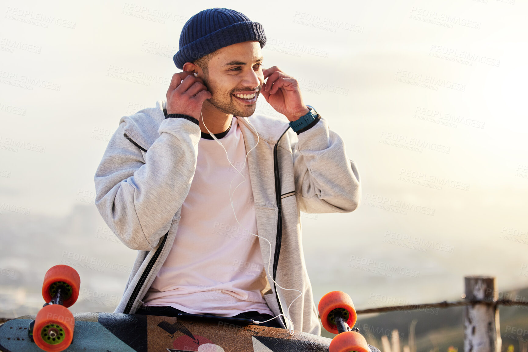 Buy stock photo Skateboarder, earphones and man listening to music, audio or podcast online and relax after skating outdoors. Skater, skateboard and person streaming to mobile radio and texting on social media