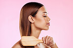 Woman, brushing hair and hairbrush beauty profile in studio for salon or hairdresser shine shampoo. Haircare of a aesthetic model on a pink background for color, glow or growth cosmetics and grooming