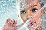 Bubble wrap, cosmetics and face of woman with makeup, red lipstick and skincare products in studio. Creative art, beauty mockup and girl with face glow, aesthetic and luxury style with plastic tear