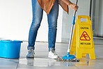 Cleaning, wet floor caution and woman mopping in building for maintenance, health or hygiene. Mop, janitor service and cleaner with warning notice, sign or safety information on slippery ground tiles