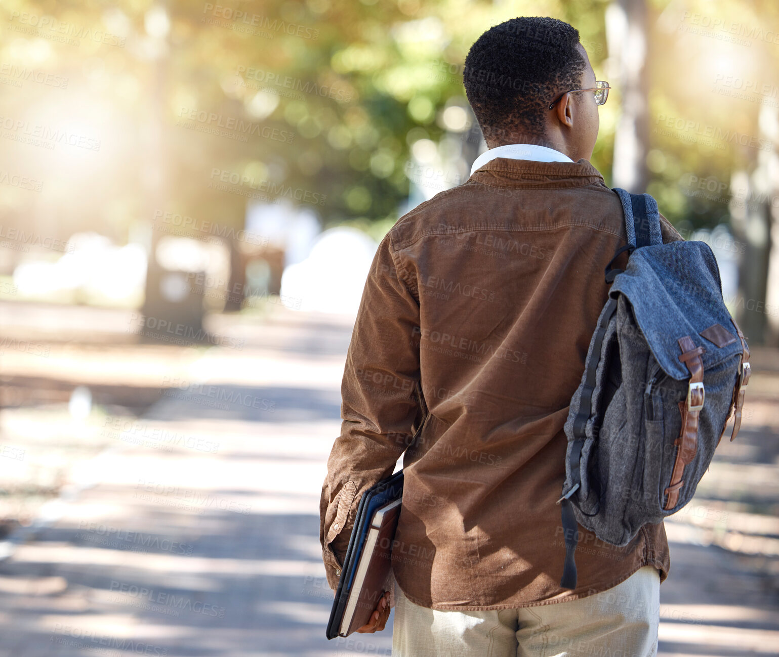 Buy stock photo Black man, walking or backpack on campus, park nature or garden for college, university or school studying development. Student, gen z and person with learning books, education bag or growth mindset