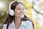 Headphones, music and business woman in nature streaming podcast or radio. Thinking, smile and happy female entrepreneur listening and enjoying audio album, song and sound track outdoors in park.