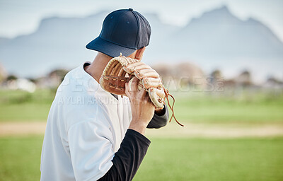 Pitcher, back view or baseball player training for a sports game on outdoor field stadium. Fitness, young softball athlete or focused man pitching or throwing a ball with glove in workout or exercise