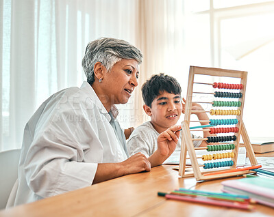 Buy stock photo Education, autism and abacus with a grandmother teaching maths to her grandchild in the home for child development. Family, homework or study and a boy learning with a senior woman tutor in a house