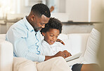 Love, sofa and father reading with his child while relaxing together in the living room of their home. Happy, bonding and African man enjoying a book, story or novel with his boy kid in family house.