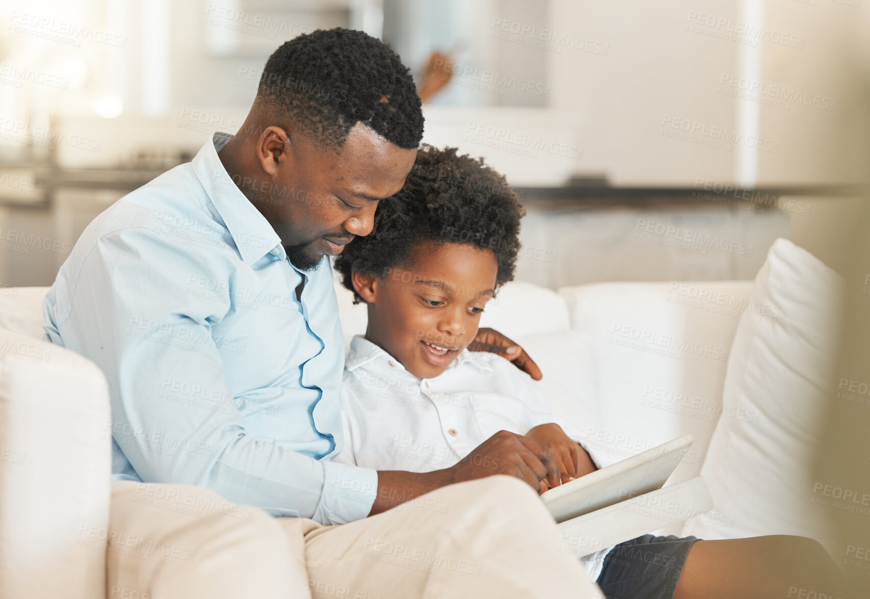 Buy stock photo Love, sofa and father reading with his child while relaxing together in the living room of their home. Happy, bonding and African man enjoying a book, story or novel with his boy kid in family house.