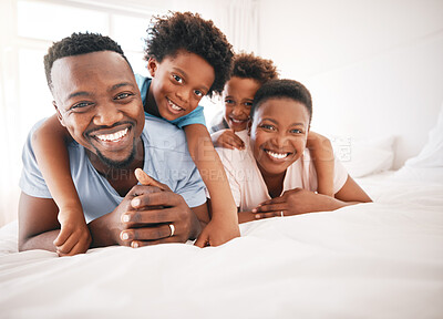 Buy stock photo Happy, bonding and portrait of a black family on a bed for playing, quality time and comfort. Smile, love and African children with parents in the bedroom for happiness, relaxation and stress relief