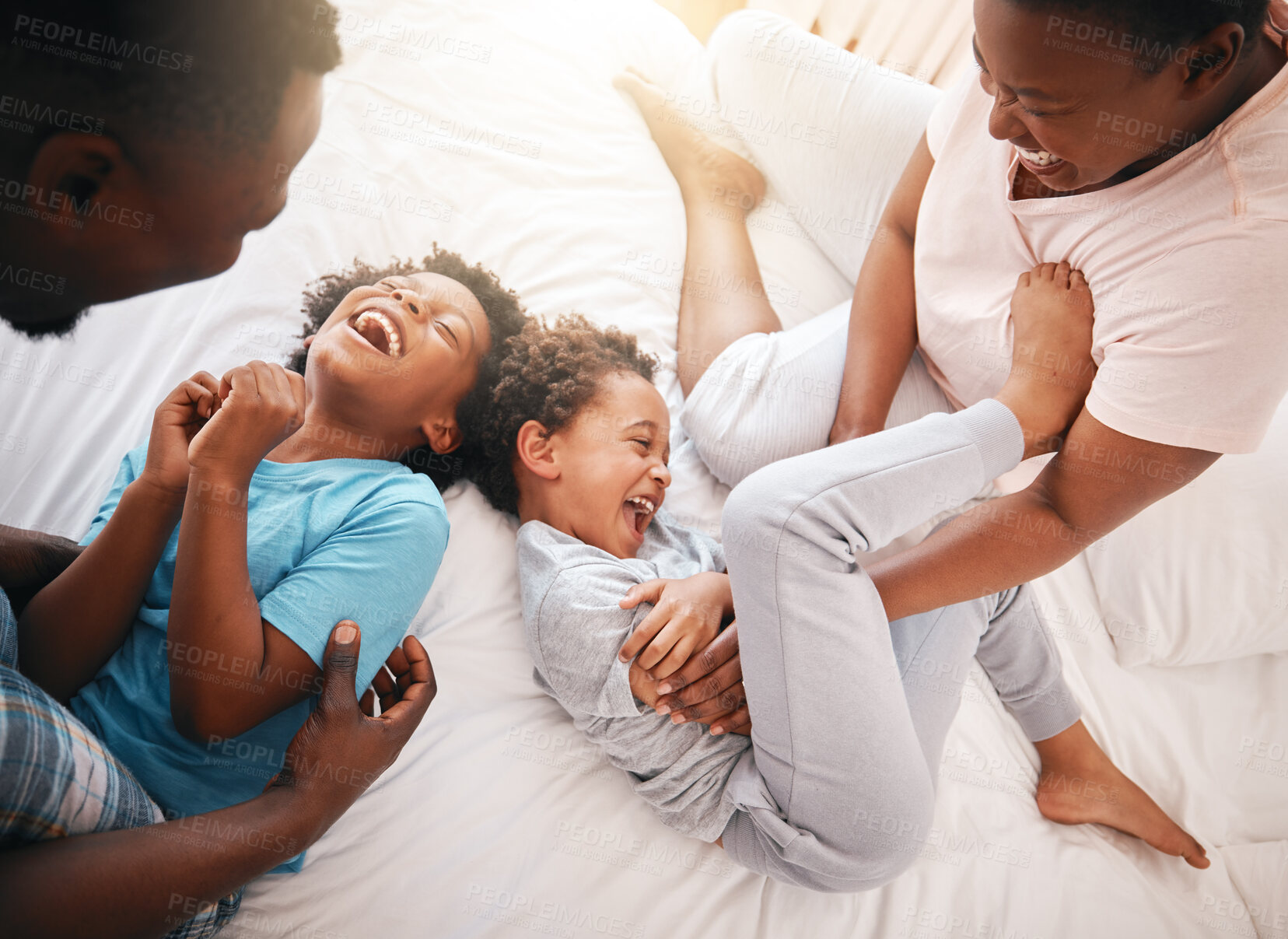 Buy stock photo Tickle, funny and relax with black family in bedroom for bonding, playful and affectionate. Laugh, happiness and crazy with parents playing with children at home for wake up, morning and silly