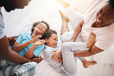 Buy stock photo Tickle, laugh and relax with black family in bedroom for bonding, playful and affectionate. Funny, happiness and crazy with parents playing with children at home for wake up, morning and silly