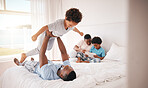 Playing, holding and father with a child on the bed for bonding, quality time and fun in the morning. Family, happy and African dad being playful, carefree and loving with a boy kid in the bedroom