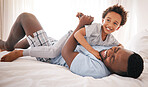 Black family, play and father with son on bed for bonding, quality time and relaxing together in bedroom. Love, happy and African dad laughing, playing and enjoy morning with child on weekend at home