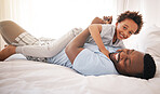 Children, love and bedroom with a playful black family having fun in the morning together after waking up. Kids, smile or laughing with a father and happy son playing or joking on a bed in their home