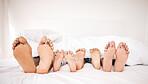 Family feet, bedroom and bed in the morning of a mother, father and young children sleeping. Mama, kids and dad foot in a house feeling relax and rest from sleep on vacation together with bonding