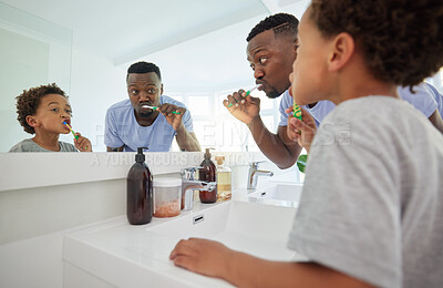 Buy stock photo Learning, brushing teeth and father with son in bathroom for dental, morning routine and cleaning. Teaching, self care and toothbrush with black man and child at home for wellness, fresh and hygiene