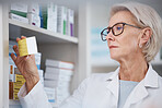 Pharmacist, pharmacy and woman reading medication label, pills or box in drugstore. Healthcare, wellness and elderly medical doctor looking at medicine, antibiotics or drugs, vitamins or supplements.