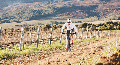 Buy stock photo Man, bicycle and cycling on gravel in nature, countryside and training for triathlon, sports and power. Cyclist, mountain bike and off road path for marathon fitness, exercise and freedom in sunshine