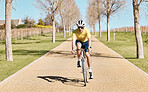 Cycling, man in bike and fitness outdoor, riding on path in countryside with helmet for safety and workout in park. Action, challenge and cardio with male athlete, training for race or triathlon 