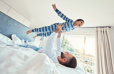 Buy stock photo Father, son and dad playing with his child on a bed holding him having fun in a bedroom feeling happy, carefree and excited. Parent, kid and dad bonding with young boy in a house together 