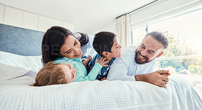 Buy stock photo Happy, love and family being playful on the bed together in the bedroom of their modern house. Happiness, excited and children having fun, playing and bonding with their parents in a room at home.