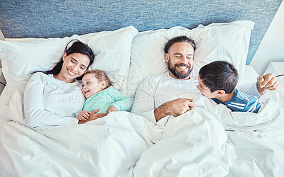 Buy stock photo Morning, relax and happy with family in bedroom for wakeup, affectionate and bonding from top view. Smile, care and sleeping with parents and children in bed at home for playful, happiness or support