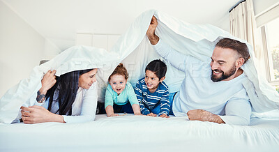Buy stock photo Family, blanket and fun by children and parents in bed, happy and smile while playing and bonding in their home. Bedroom, fort and kids with mother and father, waking up and enjoying weekend indoors