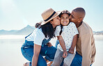 Black family, children and beach with parents kissing their daughter outdoor in nature on the sand by the ocean. Kids, love or summer with a mother and father giving a kiss to their female child