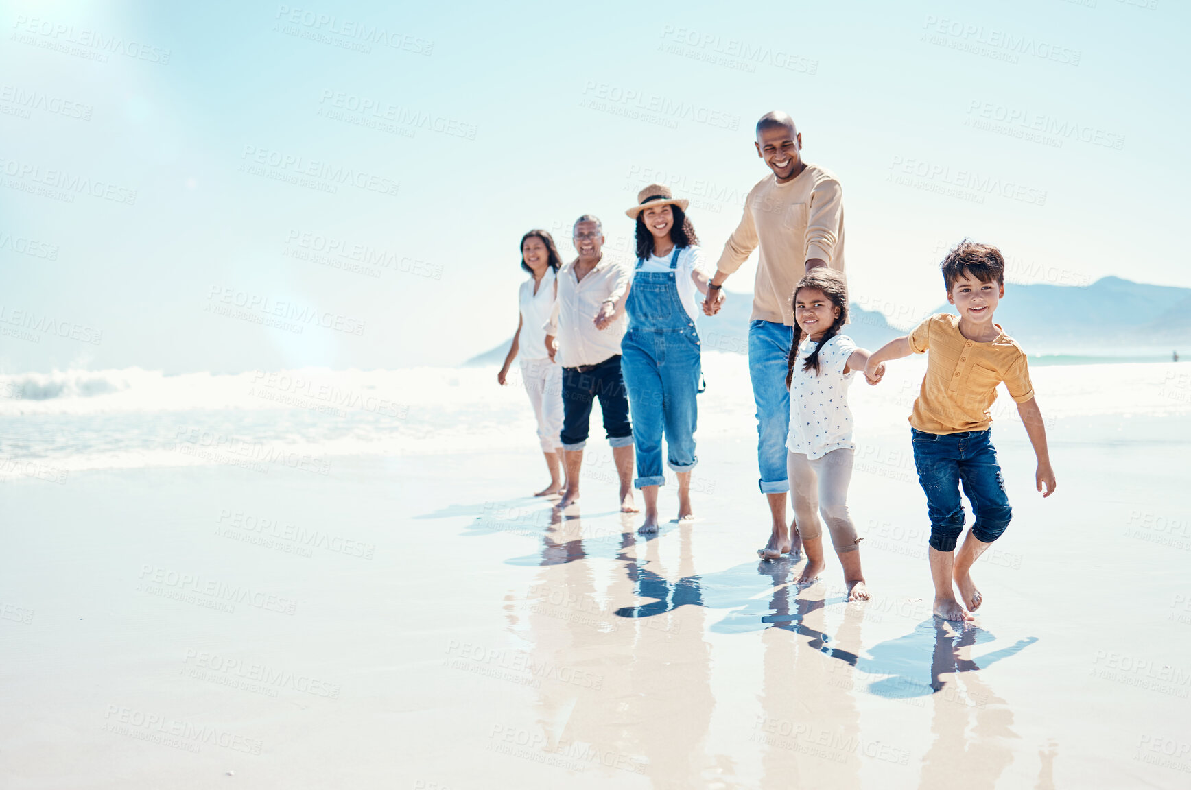 Buy stock photo Happy, portrait and a big family holding hands at the beach for a walk, bonding and playing. Love, carefree and children walking at the sea with grandparents and parents on a holiday in Spain