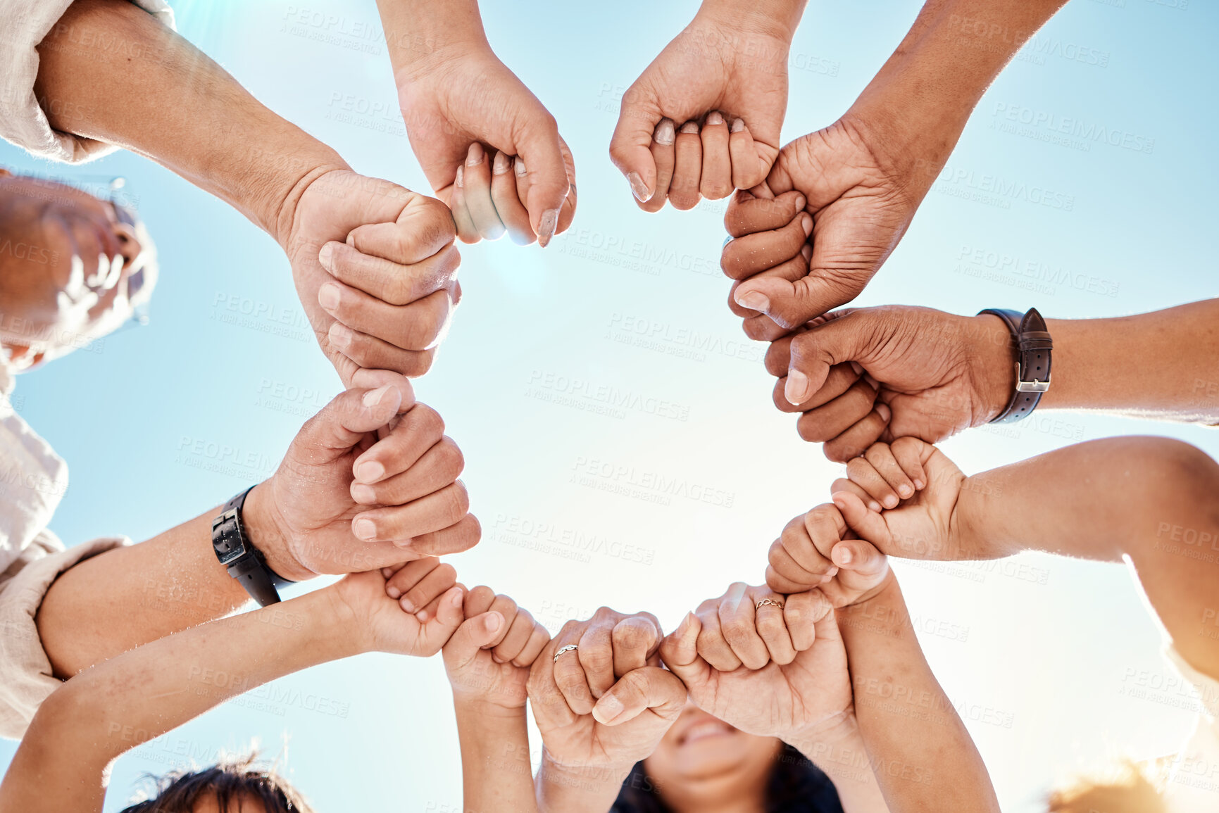 Buy stock photo Hands, family and unity with a group of people in a huddle outdoor in nature during summer together. Sky, love or solidarity with parents, grandparents and children standing in a circle from below
