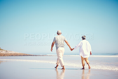 Buy stock photo Holding hands, beach and an old couple walking outdoor in summer with blue sky mockup from behind. Love, romance or mock up with a senior man and woman taking a walk on the sand by the ocean or sea
