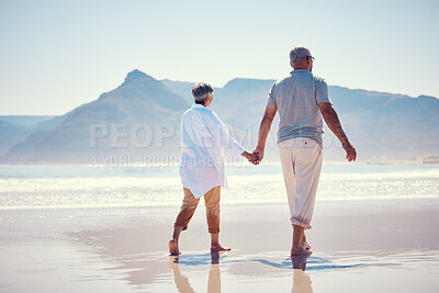 Buy stock photo Holding hands, love and an old couple walking on the beach in summer with blue sky mockup from behind. Care, romance or mock up with a senior man and woman taking a walk on the sand by the ocean