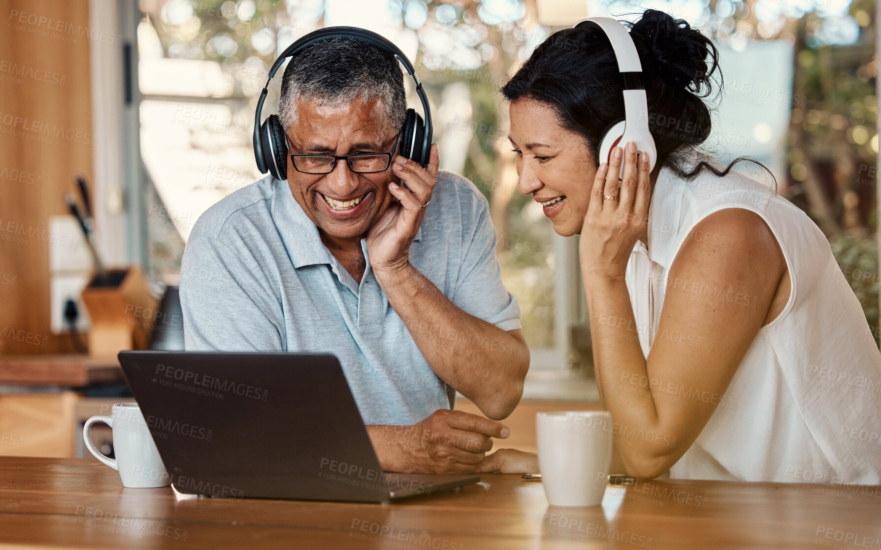 Buy stock photo Headphones, laptop and senior couple on video call in home, chatting and talking. Technology, computer and happy, elderly and retired man and woman laughing and streaming a funny online conversation