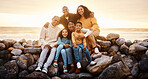 Black family, parents and children in beach portrait with excited face, sitting and rocks with grandparents. Black woman, man and kids by ocean with love hug, care or bonding on holiday by sunset sky