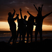 Freedom, sunset and silhouette of people at the beach while on a summer ...