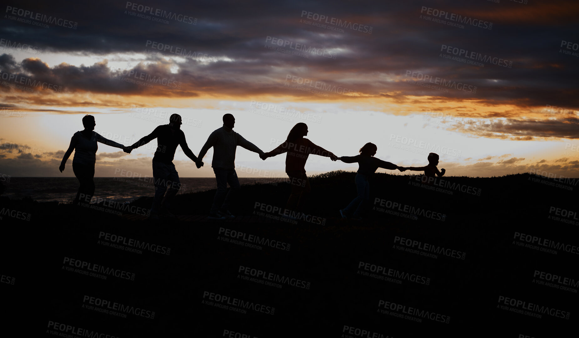 Buy stock photo Sunset, beach and silhouette of family with children by ocean for bonding, quality time and peace. Shadow, nature and grandparents, parents and kids holding hands on vacation, holiday and weekend
