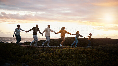 Buy stock photo Family holding hands and walking in nature for group support, growth development and adventure together in sunset. Children with grandparents for fitness, health and running by a park path or ocean 