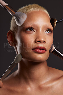 Buy stock photo Woman, face and beauty with makeup brushes for skincare cosmetics or treatment against a gray studio background. Beautiful female model with cosmetic brushing tools for facial, self care or love