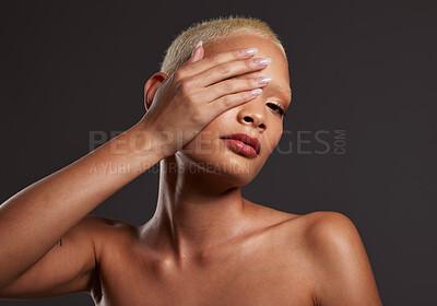 Buy stock photo Posing, skincare and portrait of a woman with makeup isolated on a black background. Beauty, grooming and African model with hand on face, covering eye and showing a glow on skin on a backdrop