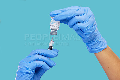 Buy stock photo Mockup, closeup and hands with needle, vial and vaccination for diagnosis against a blue studio background. Zoom, hands and gloves, with medicine, cure and vaccination for medical diagnosis or result
