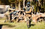 Soldier, paintball and running with gun for intense battle or war in the forest pushing to attack. Active paintballer rushing or moving fast in extreme adrenaline team sport with weapon or camouflage