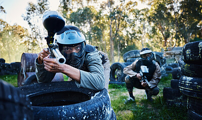 Buy stock photo Team, paintball and tires for cover, hiding or protection while firing or aiming down sights together in nature. Group of paintballers waiting in teamwork for opportunity to attack or shoot in sports