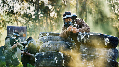 Buy stock photo Team, paintball and tires for cover bunker or protection while firing or aiming down sights together in nature. Group of people waiting in teamwork for opportunity to attack or shoot in extreme sport