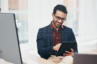 Buy stock photo Office, happy Indian man at desk with tablet and computer, reading good news email or successful sales report online. Business, smile and communication with internet, social media or research on web.