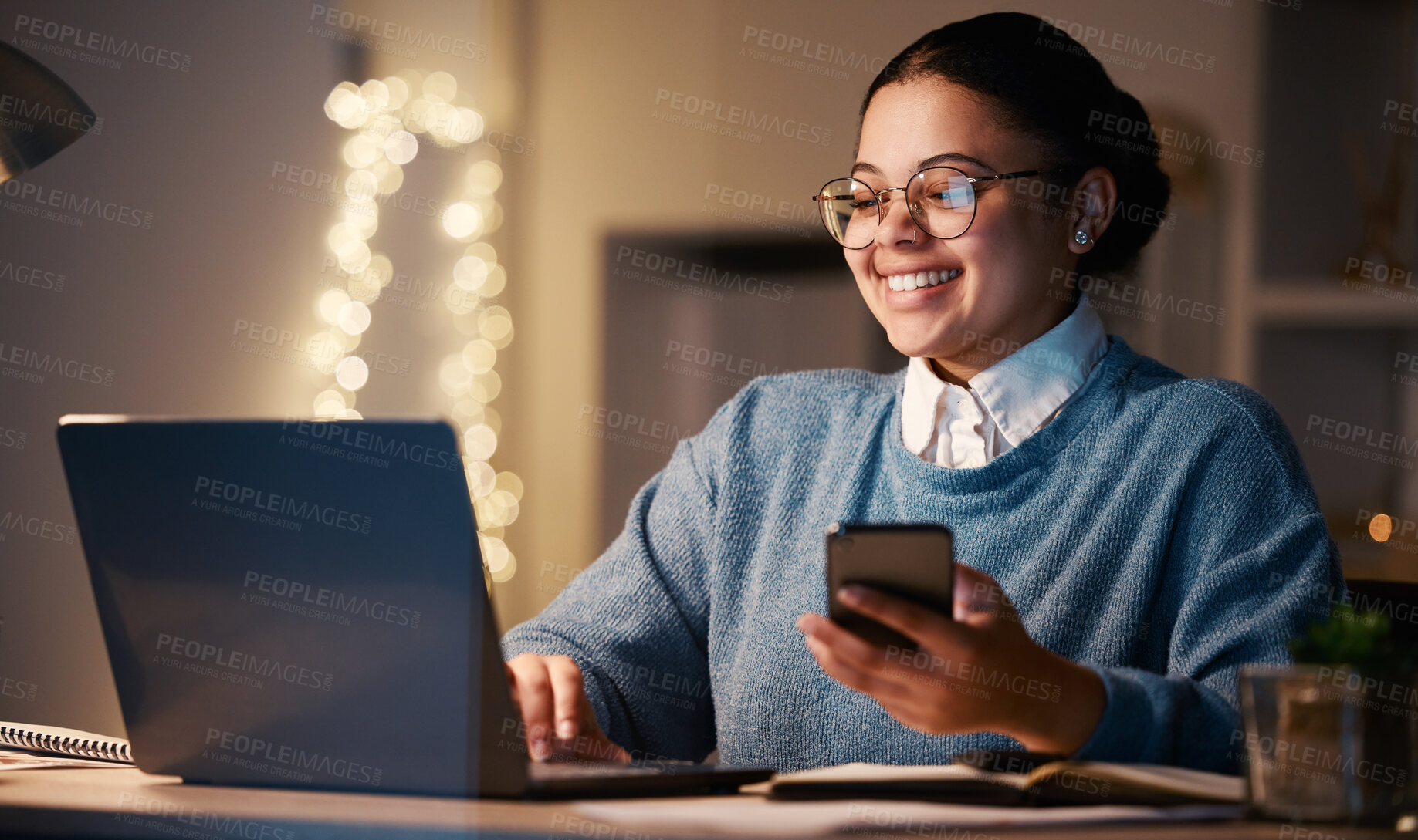 Buy stock photo Woman, phone and student with laptop in home for web browsing, project or studying at night. Bokeh, mobile and smile of happy business female, freelancer or remote worker with computer for research.