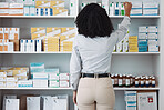 Pharmacy, medicine and shelf with black woman in store for healthcare, drugs dispensary and treatment prescription. Medical, pills and shopping with pharmacist for check, label information or product