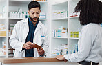 Pharmacy, man and customer with medicine, instructions and conversation in drug store, medical supplements and prescription. Male employee, female client and pharmacist with antibiotics or healthcare
