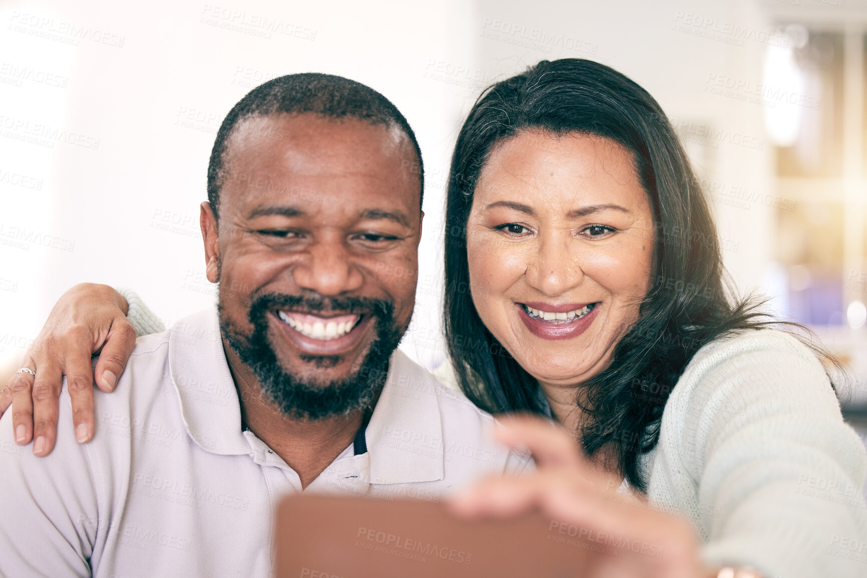 Buy stock photo Selfie, interracial and couple with a hug for bonding, memory together or quality time. Smile, embrace and mature man and woman smiling for a picture for social media, love or happiness at home