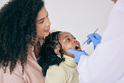 Buy stock photo Children, mother and a girl at the dentist for oral hygiene or a checkup to search for a cavity or gum disease. Kids, dental or healthcare with a female child and mother at the orthodontist