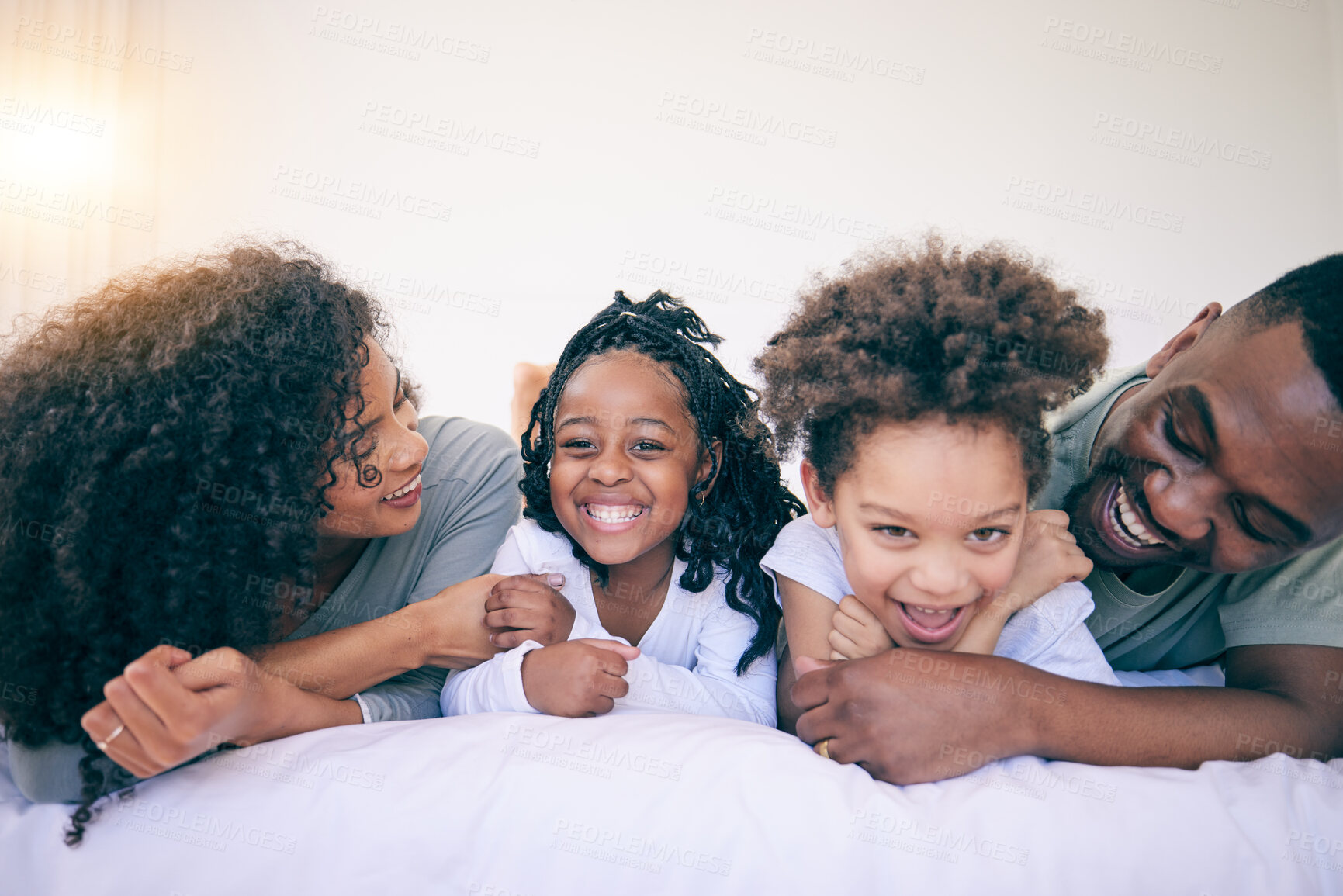 Buy stock photo Happy, laugh and morning with black family in bedroom for wake up, bonding and affectionate. Weekend, smile and care with parents and children at home for playful, funny and free time together