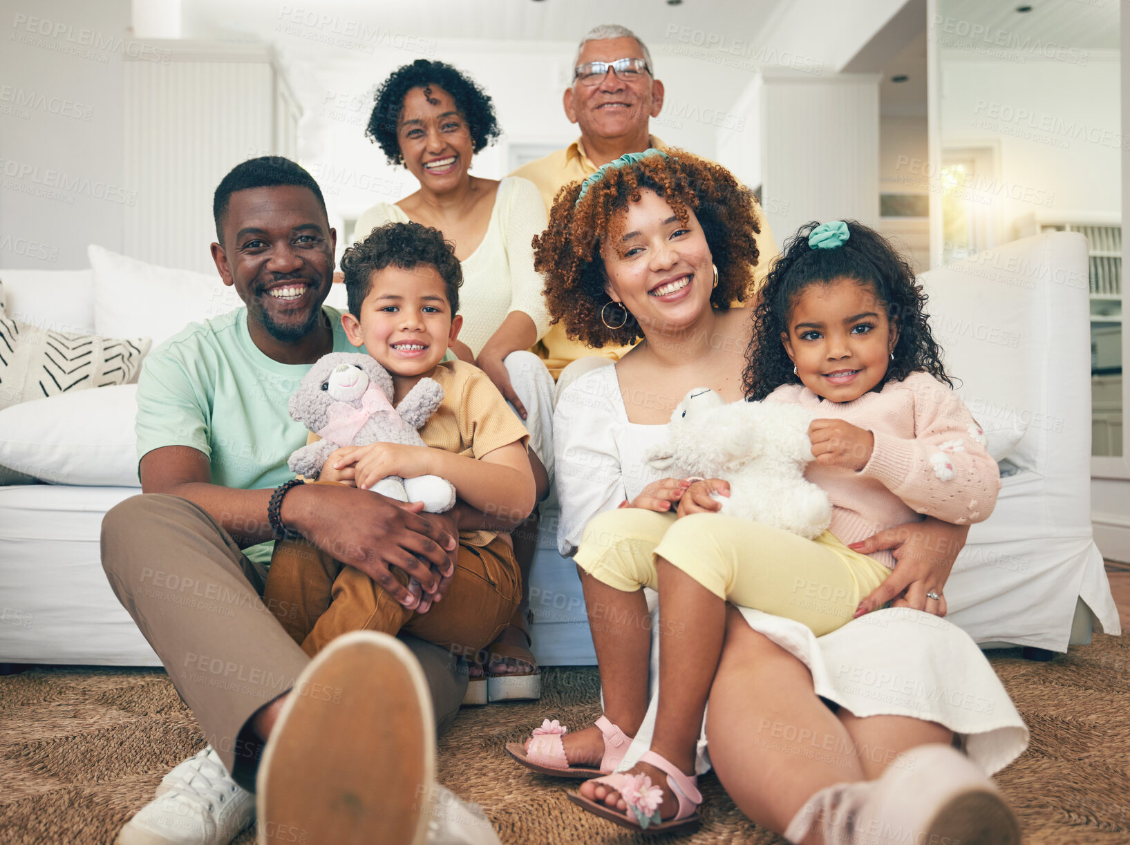 Buy stock photo Happy, interracial and portrait of a big family bonding, smiling and playing during a visit. Smile, quality time and parents, grandparents and children sitting in a living room for happiness at home