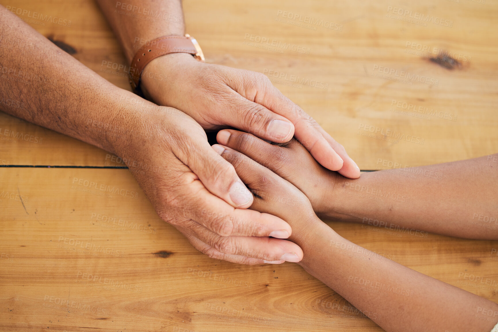 Buy stock photo Top view of couple holding hands on table for love, care and empathy of mental health, trust and counseling. Closeup people, helping hand and support on wooden surface for gratitude, kindness or hope